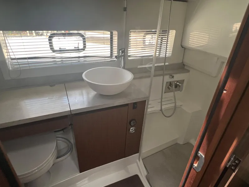 Slide: The Image of 2024 Jeanneau Leader 12.5 boat bathroom with modern fixtures and ample natural light. - 13