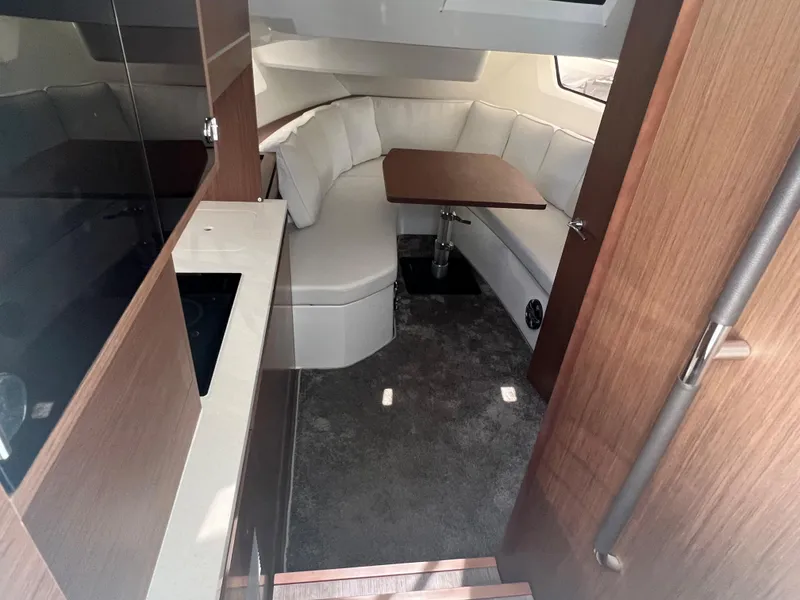 Slide: The Image of 2024 Jeanneau Leader 12.5 interior with modern seating and dining area. - 9