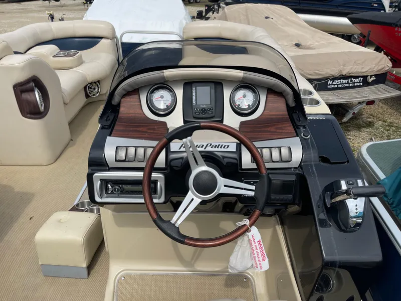 Slide: The Image of AquaPatio 240EL3 Triple 2015 boat dashboard with steering wheel and gauges. - 5