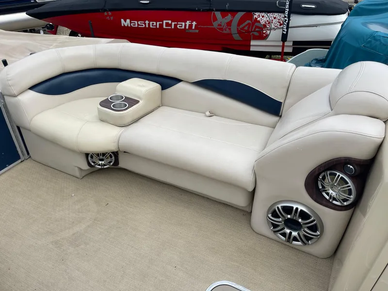 Slide: The Image of AquaPatio 240EL3 Triple 2015 boat interior with beige seating and built-in speakers. - 6