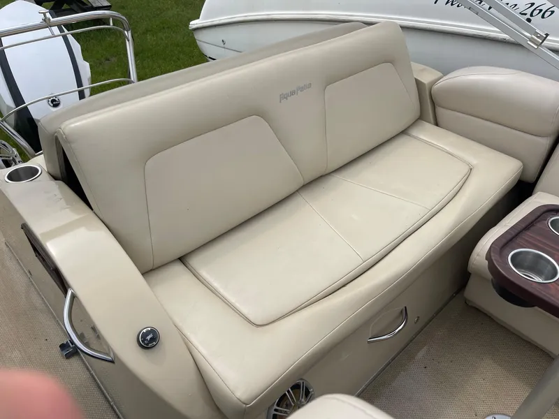 Slide: The Image of 2015 AquaPatio 240EL3 Triple boat interior with beige seating and cup holders. - 8