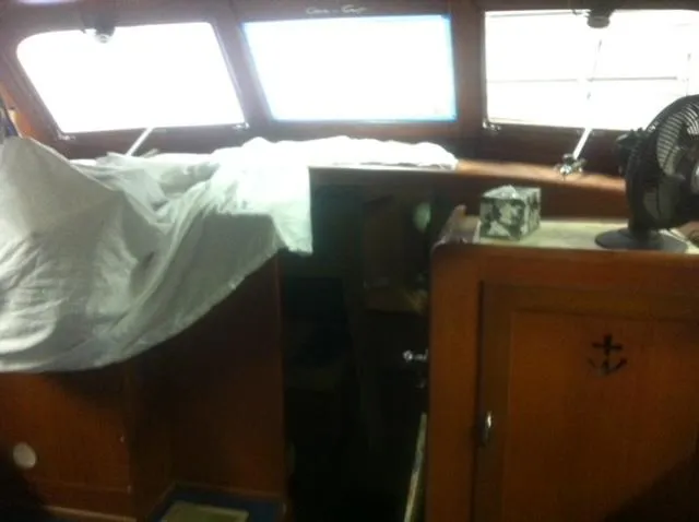Slide: The Image of 1952 Chris-Craft Buccaneer boat interior with wooden cabinetry and covered seating area. - 15