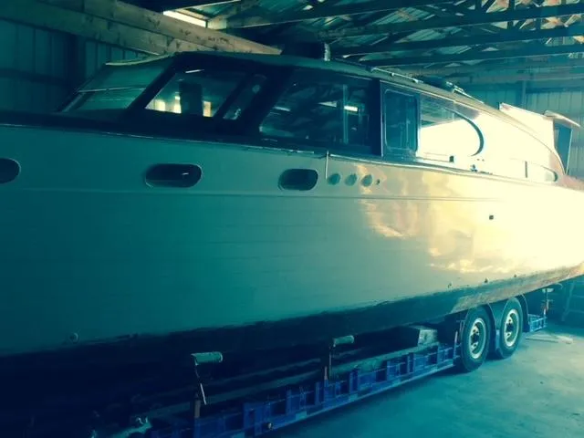 Slide: The Image of 1952 Chris-Craft Buccaneer boat on trailer in a garage setting. - 2