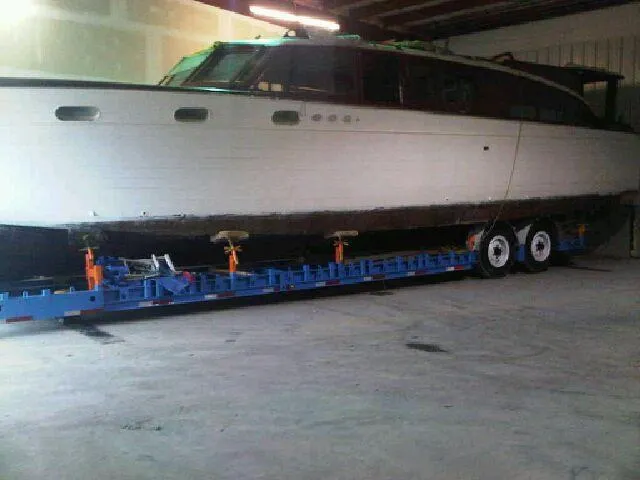 The Image of 1952 Chris-Craft Buccaneer boat on trailer in a garage setting. - 0