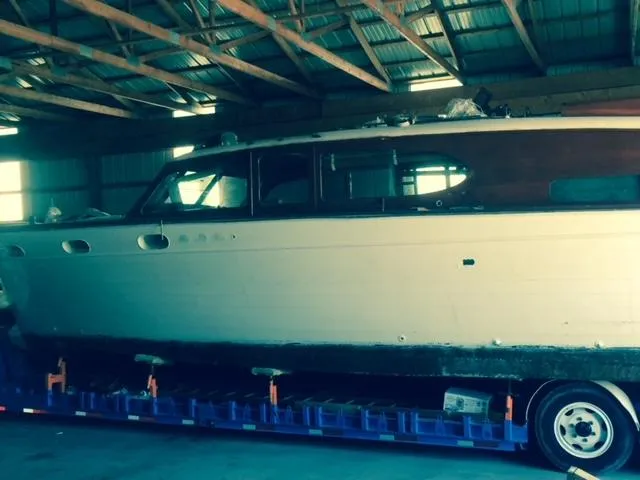 Slide: The Image of 1952 Chris-Craft Buccaneer boat in storage, side view, under wooden roof. - 3