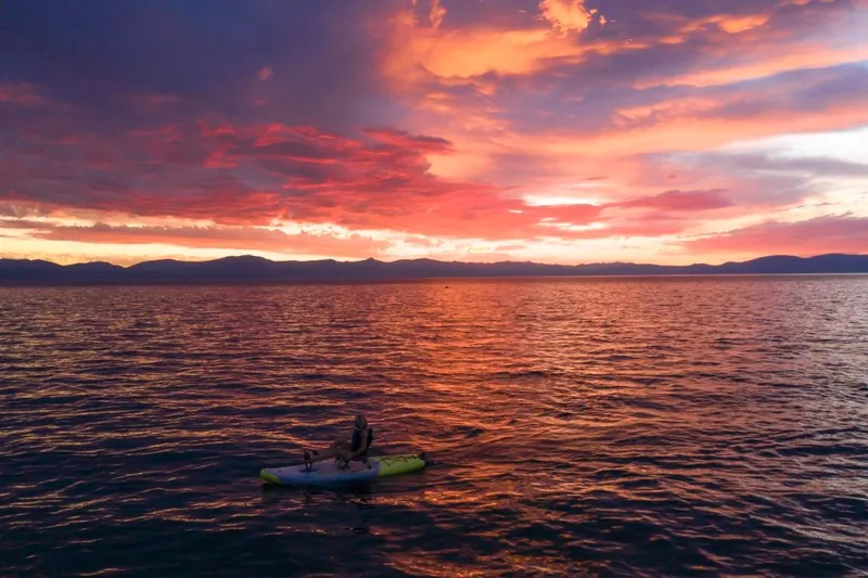 Slide: The Image of Person kayaking on a Hobie iTrek 9 Ultralight 2023 at sunset on a serene lake. - 14