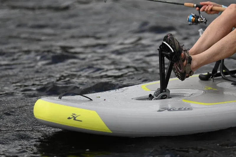 Slide: The Image of Hobie iTrek 9 Ultralight 2025 kayak on water, featuring pedal system and fishing rod. - 13