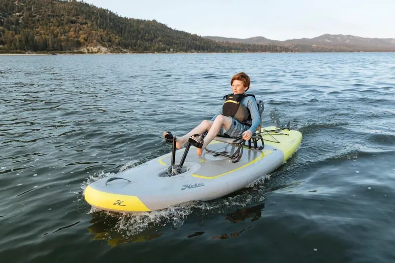 The Image of Young person kayaking on a 2023 Hobie iTrek 9 Ultralight in a scenic lake. - 0