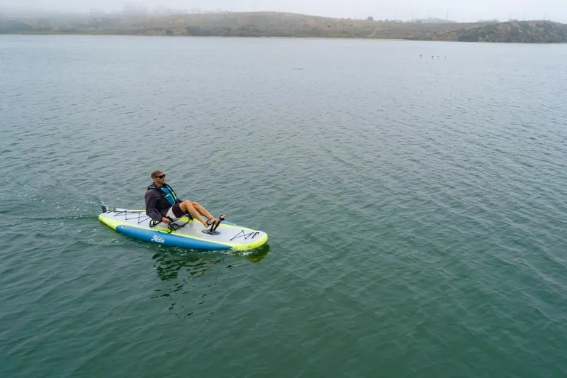 Slide: The Image of Person paddling on a 2023 Hobie ITREK 11 inflatable kayak in a calm lake. - 3