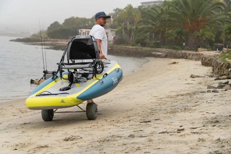Slide: The Image of Man transporting 2023 Hobie ITREK 11 kayak on a beach. - 7