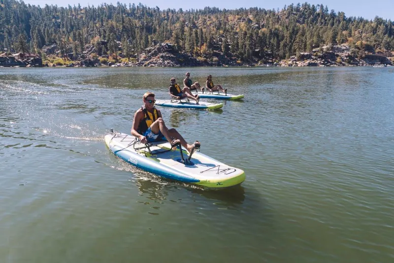 Slide: The Image of People riding 2023 Hobie ITREK 11 pedalboards on a scenic lake. - 8