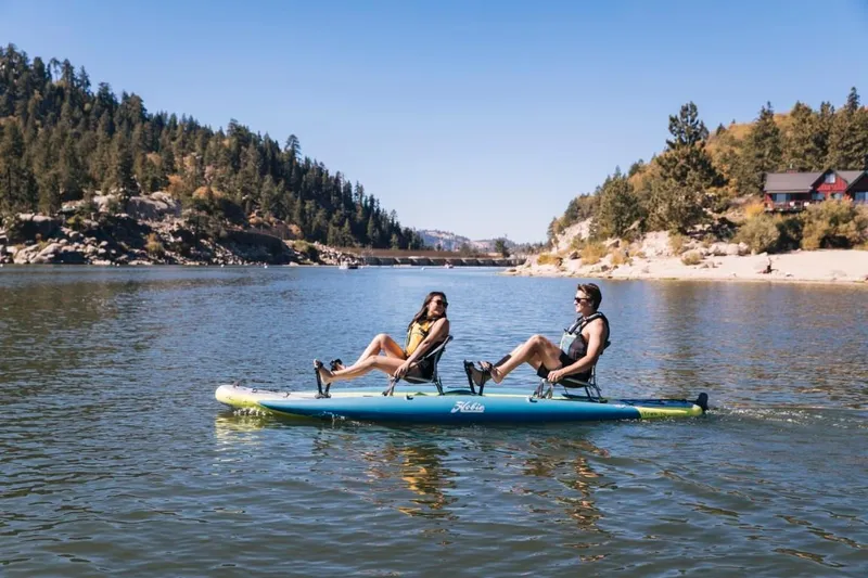 Slide: The Image of Two people kayaking on a Hobie iTrek 14 Duo in a scenic lake, 2023 model. - 1