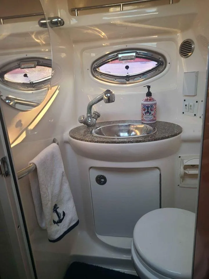 Slide: The Image of 2010 Chaparral 270 Signature boat bathroom with sink, mirror, and porthole window. - 15