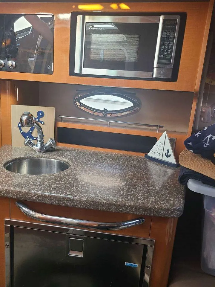 Slide: The Image of 2010 Chaparral 270 Signature boat interior with kitchenette, microwave, and sink. - 16