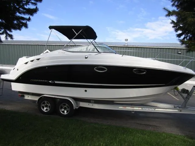 Slide: The Image of 2010 Chaparral 270 Signature boat on trailer, black and white design, parked outdoors. - 2