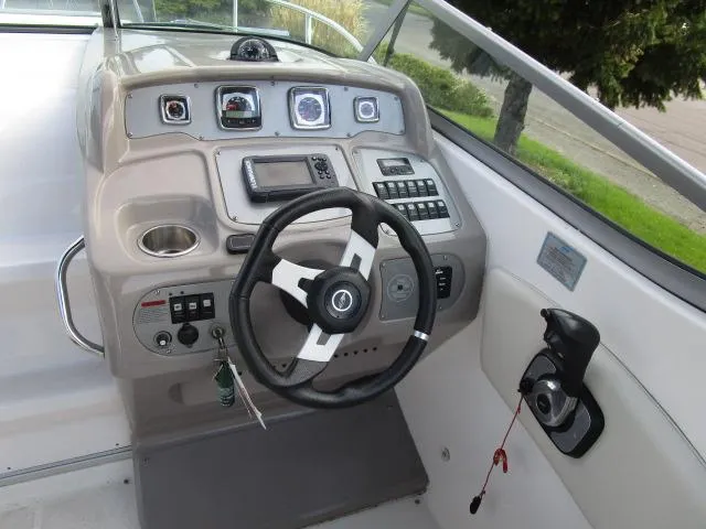 Slide: The Image of 2010 Chaparral 270 Signature boat dashboard with steering wheel and control panel. - 6
