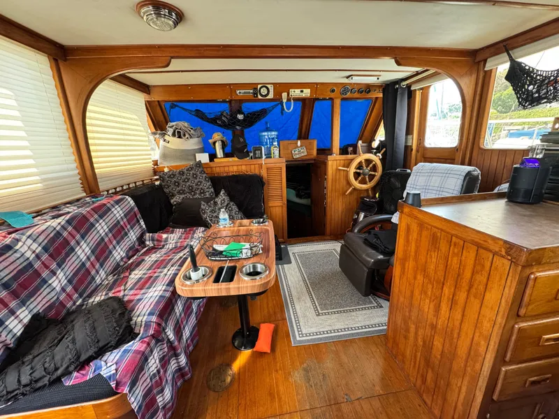 Slide: The Image of 1980 DeFever Trunk Cabin Motoryacht interior with cozy seating, wooden accents, and nautical decor. - 6