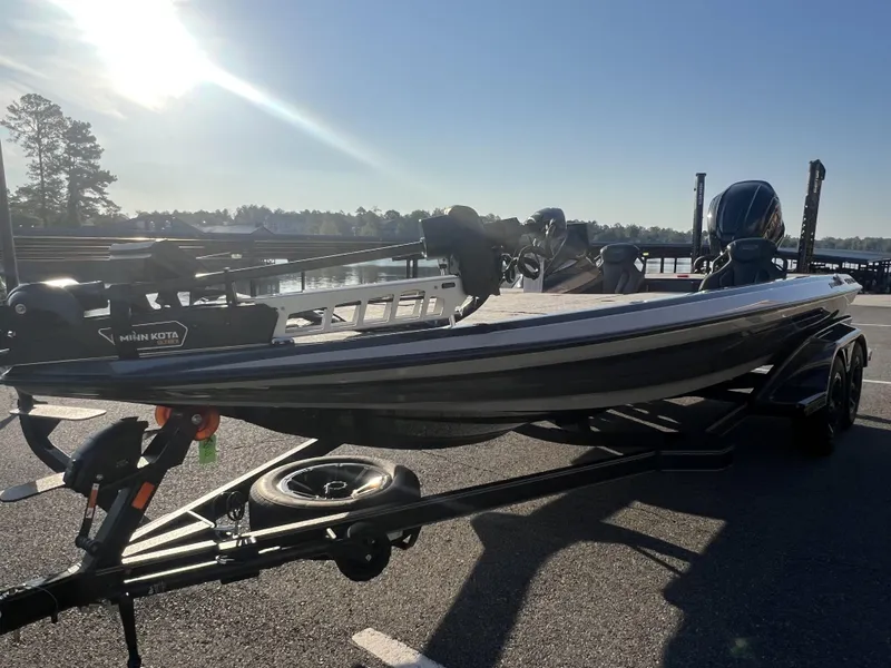 Slide: The Image of 2025 Skeeter FXR20 Limited boat on trailer, parked near a scenic lake under clear skies. - 8