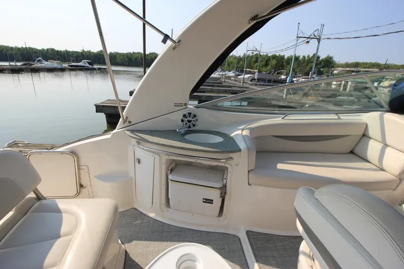 Slide: The Image of 2006 Chaparral 276 Signature Cruiser interior with seating and storage, docked at marina. - 11