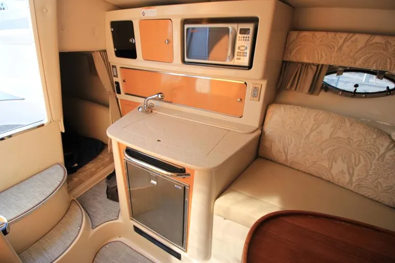 Slide: The Image of 2006 Chaparral 276 Signature Cruiser interior with kitchenette, microwave, and seating area. - 25