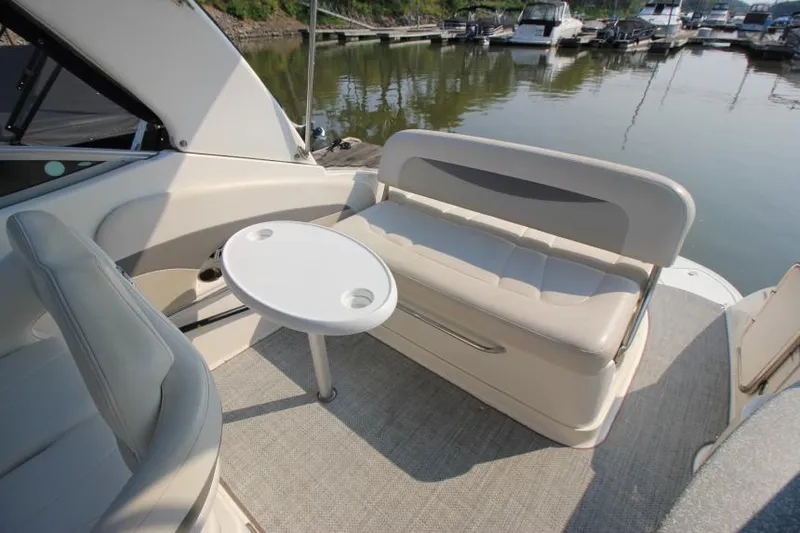 Slide: The Image of 2006 Chaparral 276 Signature Cruiser interior with seating and table, docked at marina. - 9