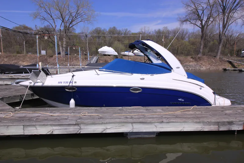 The Image of 2006 Chaparral Signature 276 boat docked on a sunny day, featuring a sleek blue and white design. - 0