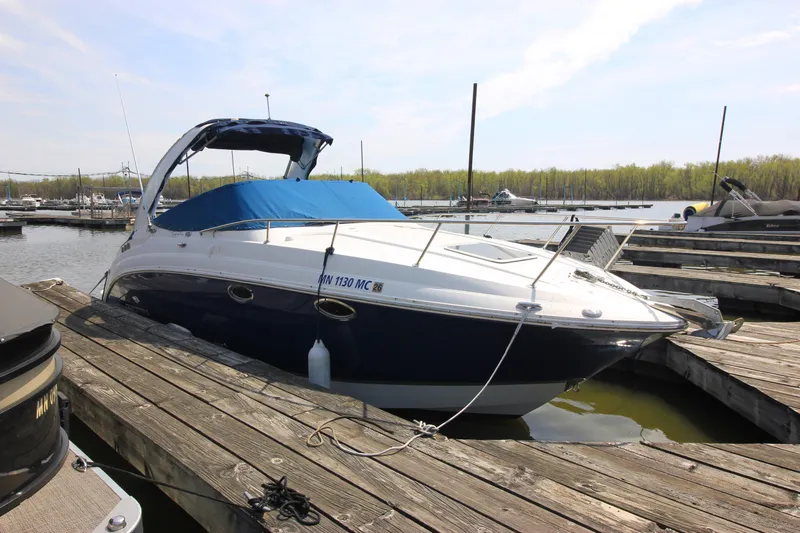 Slide: The Image of 2006 Chaparral Signature 276 boat docked at a marina, featuring a blue canopy. - 2