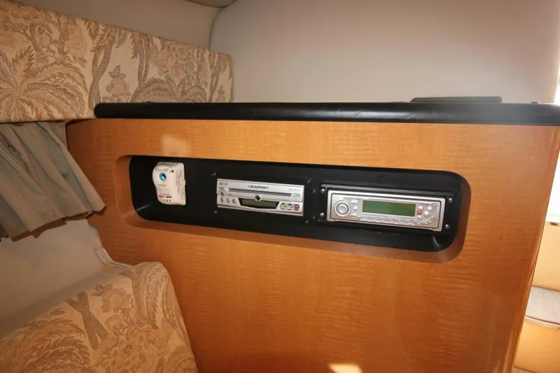 Slide: The Image of 2006 Chaparral 276 Signature Cruiser interior with built-in stereo system and wood paneling. - 22