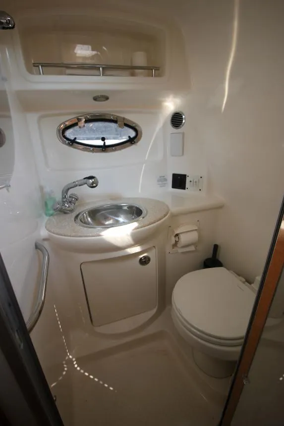 Slide: The Image of 2006 Chaparral 276 Signature Cruiser bathroom with sink, toilet, and porthole window. - 31