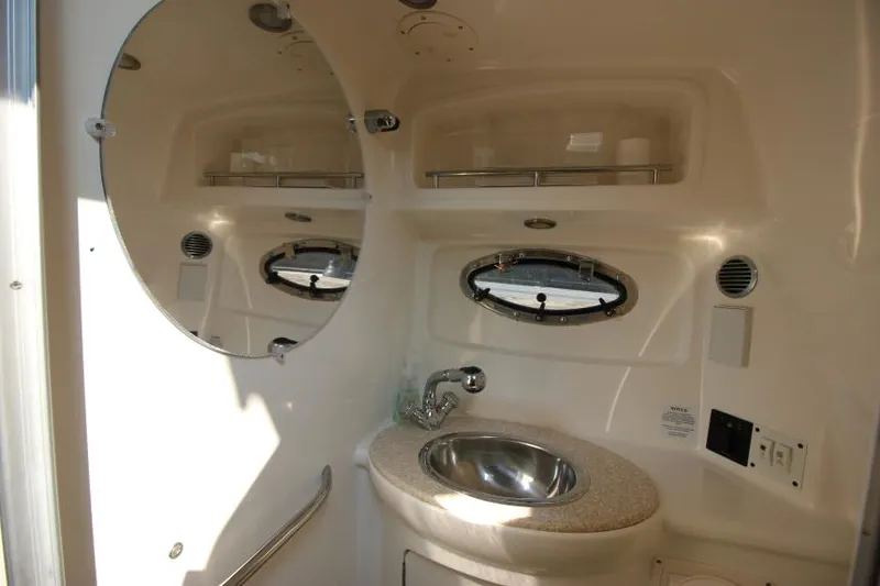 Slide: The Image of 2006 Chaparral 276 Signature Cruiser bathroom with sink, mirror, and porthole window. - 32