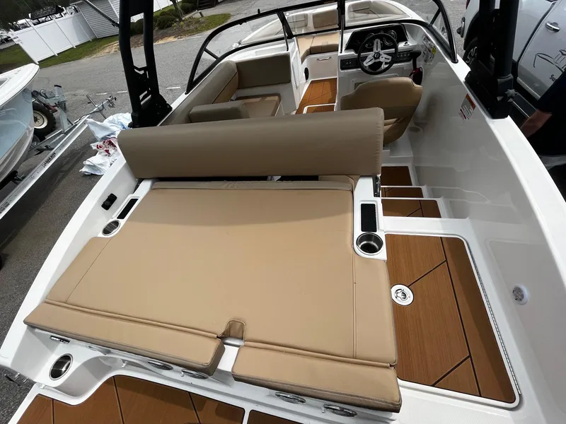 Slide: The Image of 2024 Bayliner DX2000 boat interior with tan seating and wood accents. - 6