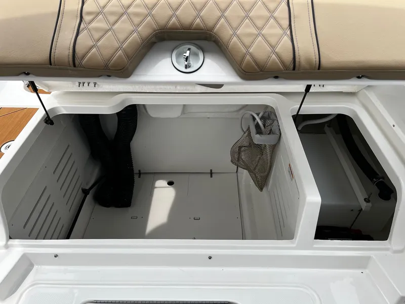 Slide: The Image of 2024 Bayliner DX2000 boat storage compartment with beige cushioned seating. - 8