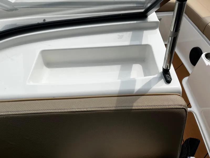 Slide: The Image of 2024 Bayliner DX2000 boat interior detail with beige seating and white storage compartment. - 13