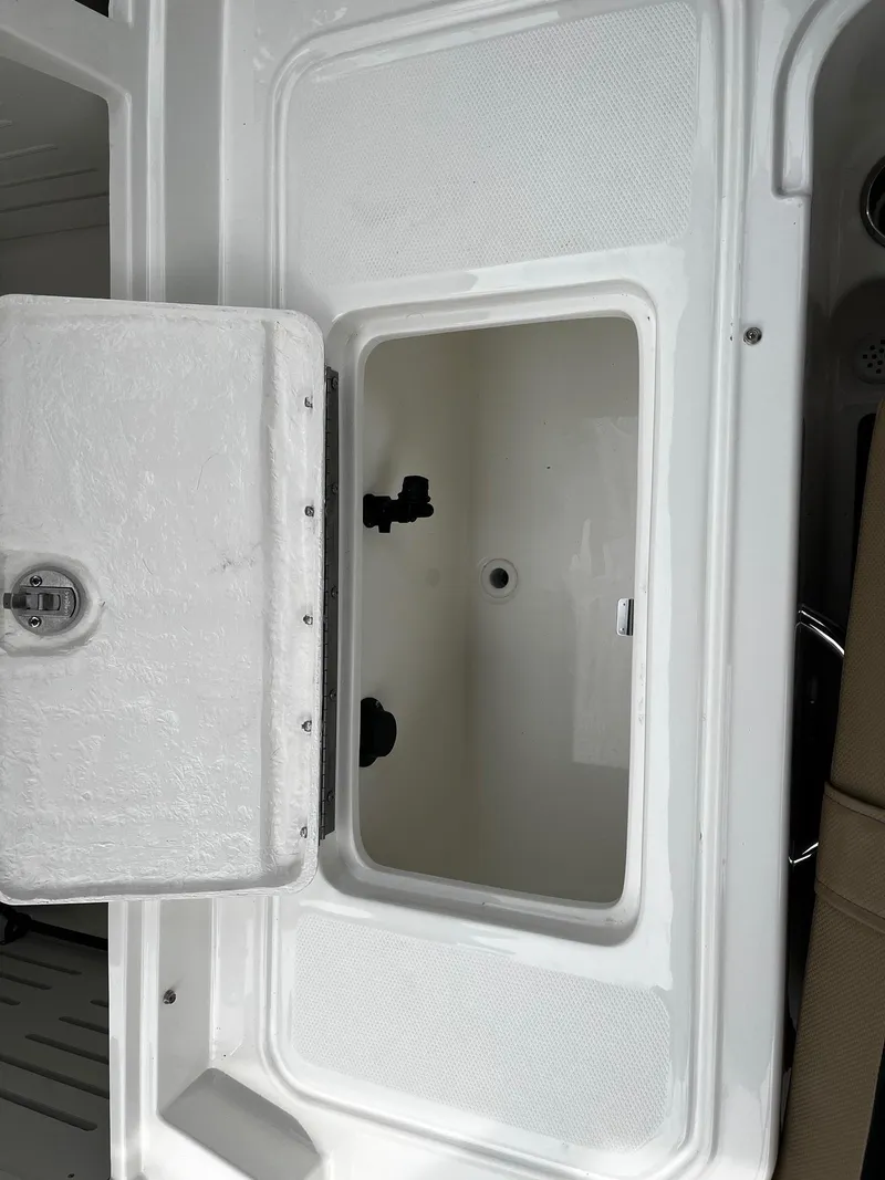 Slide: The Image of 2024 Bayliner DX2000 boat storage compartment with open lid. - 7