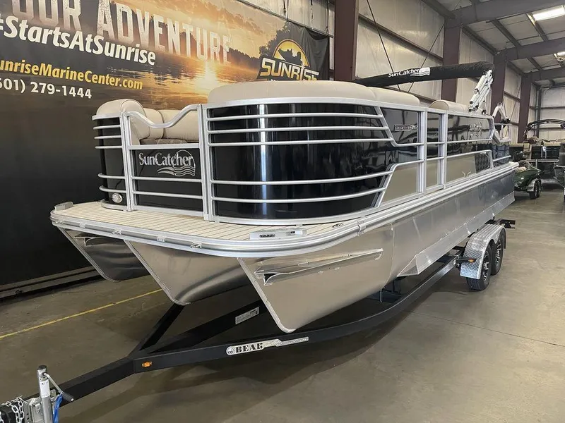 Slide: The Image of 2023 SunCatcher Elite 324SS pontoon boat on display in a showroom. - 13