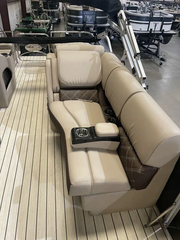 Slide: The Image of 2023 SunCatcher Elite 324SS boat interior with beige leather seating and cup holders. - 7