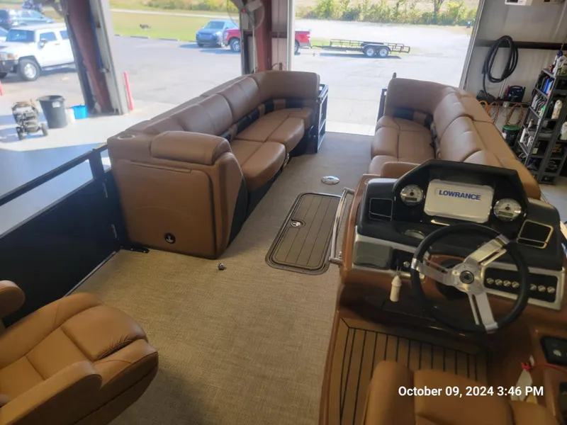 Slide: The Image of 2021 Regency 250 LE3 Sport boat interior with brown seating and steering console. - 3