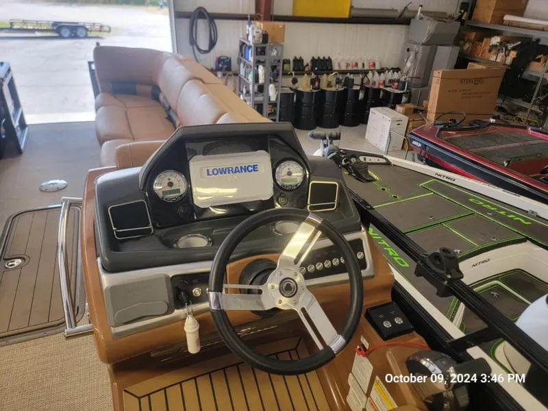 Slide: The Image of 2021 Regency 250 LE3 Sport boat dashboard with Lowrance display in a garage setting. - 5