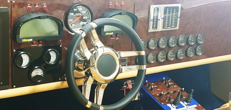Slide: The Image of Steering wheel and dashboard of a 2020 Skater 50 boat with gauges and controls. - 16