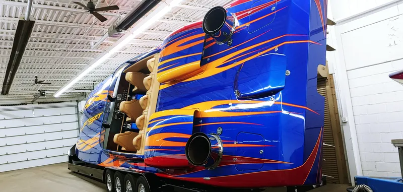 Slide: The Image of Colorful Skater 50 speedboat in a garage, 2020 model, with vibrant blue and orange design. - 3