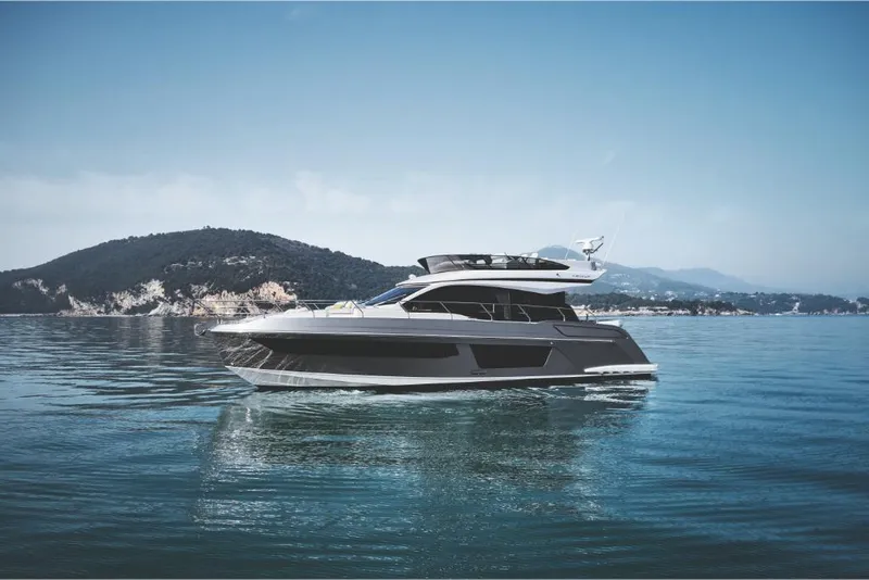 Slide: The Image of 2023 Azimut 53 yacht cruising on calm waters with scenic mountain backdrop. - 4