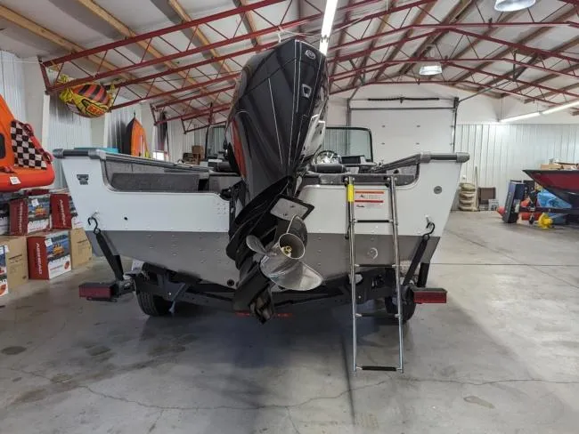 Slide: The Image of 2025 Lund 1975 Pro V Sport boat in a garage, rear view with outboard motor. - 10