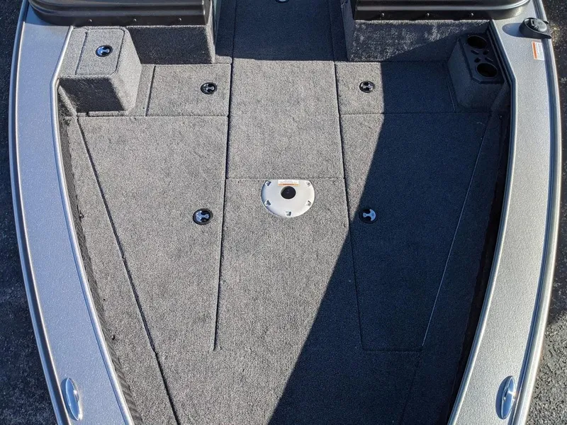 Slide: The Image of 2025 Lund 2075 Pro V Sport boat deck with carpeted surface and storage compartments. - 2