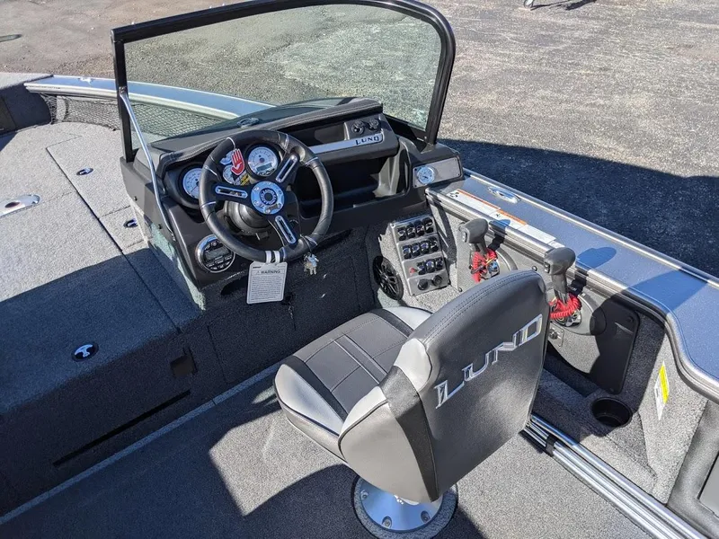 Slide: The Image of 2025 Lund 2075 Pro V Sport boat interior with steering wheel and captain's chair. - 8