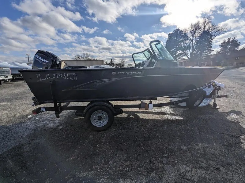 Slide: The Image of 2024 Lund 1775 Adventure Sport boat on trailer under a cloudy sky. - 9
