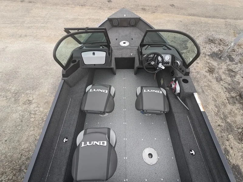 Slide: The Image of 2025 Lund 1650 Angler boat interior with seating and steering console. - 2