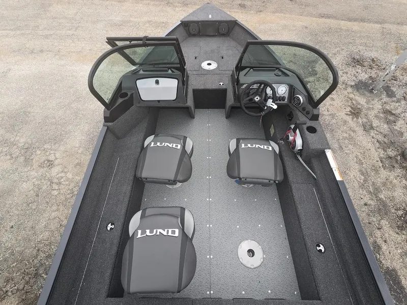 Slide: The Image of 2025 Lund 1650 Angler boat interior with three seats and steering console. - 3