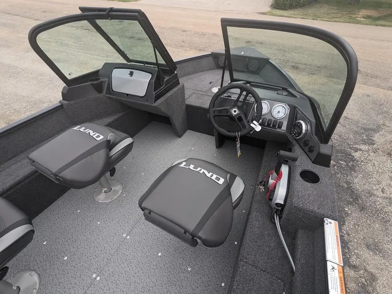Slide: The Image of 2025 Lund 1650 Angler boat interior with steering wheel and seating. - 7