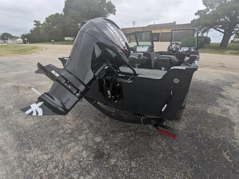 Slide: The Image of 2025 Lund 1650 Angler boat with powerful outboard motor in a parking area. - 9