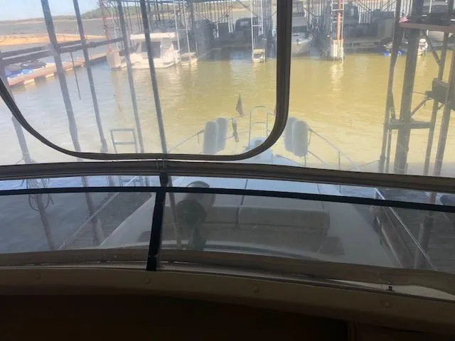 Slide: The Image of View from the helm of a 1983 Sea Ray 390 Sport Fisherman docked at a marina. - 11